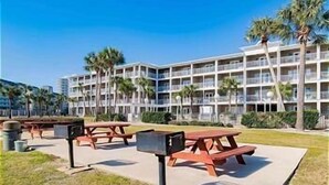 A hotel with multiple balconies, outdoor seating areas, and palm trees.
