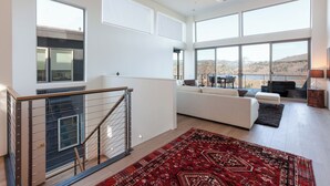 A spacious living area with a large window, a staircase, and a view of the outdoors. - NEW Construction, Magnificent NEW Townhome in dt Hood River w/Rivr views, garage (Hood River)