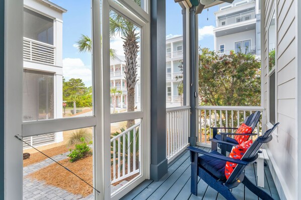 A porch with a view of a residential area, including a multi-story building and a palm tree. - Thanksgiving on 30A: 3 King Suites, Cart & Pool (Santa Rosa Beach)