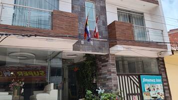 A multi-story hotel with a stone facade, balconies, and a visible entrance with steps.
