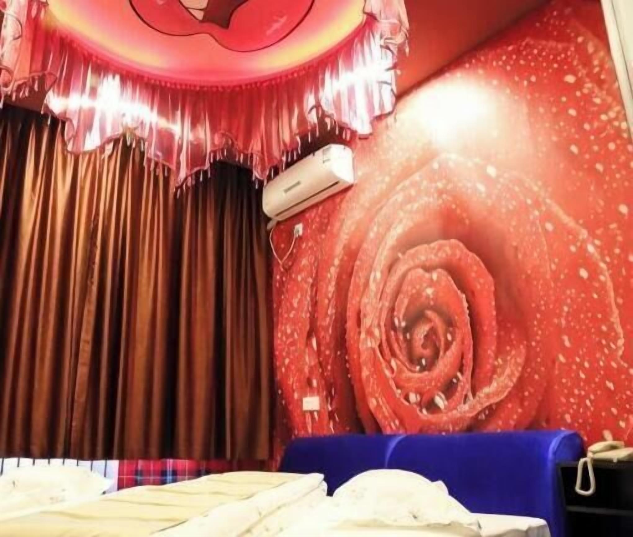 Una stanza con un divano blu, una parete rossa con un motivo a spirale e una tenda.