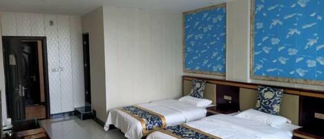 A hotel room with two beds, a wooden headboard, and a large decorative wall panel.