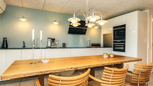 Une cuisine moderne avec une table à manger en bois et quatre chaises en bois.