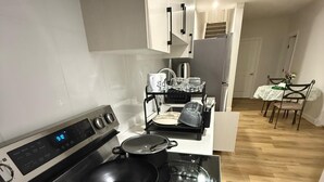 Une cuisine moderne avec un fourneau noir, une horloge numérique et un égouttoir à vaisselle.