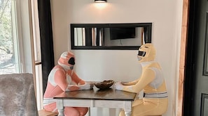 Twee mensen in ruimtepakken zitten aan een tafel met een kom in het midden.