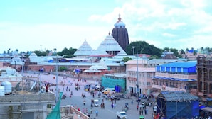 A busy urban street with traditional buildings and a prominent temple in the background. - DhamStay Hotel Santosh Inn Near Temple (Puri)
