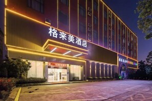 Un hotel con señalización iluminada y una entrada bien iluminada.