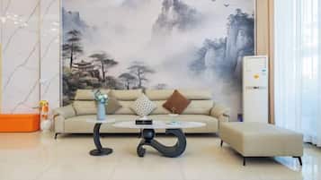 A modern living room with a sofa, two coffee tables, and a decorative wall mural.
