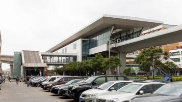 A row of parked cars in front of a modern building with a flat roof and large windows.