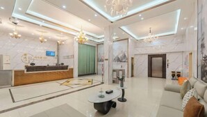 A modern hotel lobby with a reception desk, seating area, and a chandelier. - Guangzhou Gelaimei Hotel (Zhuliao Subway Station) (Guangzhou)