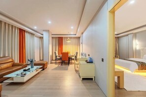 A hotel room with a bed, a sofa, a coffee table, a desk, and a chair. - Guangzhou Gelaimei Hotel (Zhuliao Subway Station) (Guangzhou)