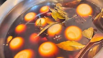 A pot with a liquid, containing round objects and leaves.