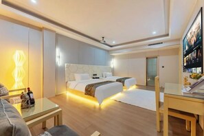 A modern hotel room with a large bed, a glass coffee table, and a TV on the wall. - Guangzhou Gelaimei Hotel (Zhuliao Subway Station) (Guangzhou)