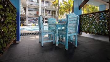 A poolside area with blue chairs and a pool.
