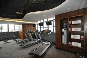 Ein modernes Fitnessstudio mit Laufbändern, Ergometer und einem Wasserspender.