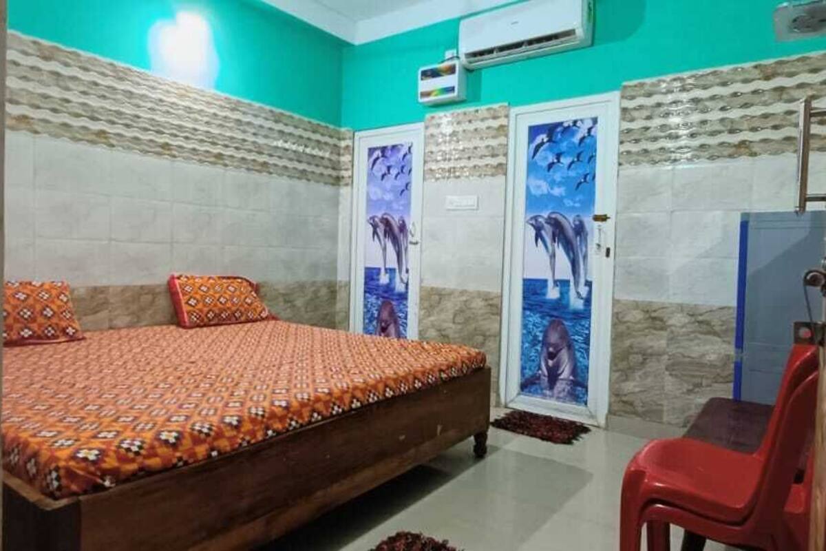 Een slaapkamer met een bed, een rode stoel en twee deuren met dolfijnenmuziek.