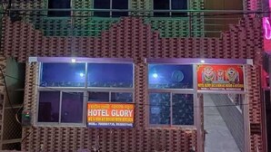 A multi-story building with a sign for "Hotel Glory" indicating it offers A/C rooms with a kitchen. - DhamStay Hotel Glory Near Golden Beach (Puri)