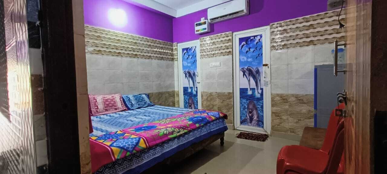 A bedroom with a bed, a red chair, and a wall with a mural.