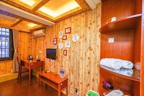 A wooden-paneled room with a desk, chair, TV, and shelves with towels. - Yiyun Boutique Hostel (Shanghai Zhujiajiao) (Shanghai)