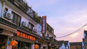 A traditional building with multiple air conditioning units on the exterior, a signboard with Chinese characters, and a lantern hanging outside. - Chang'an Hotel (Zhujiajiao Ancient Town Branch, Qingpu, Shanghai) (Shanghai)