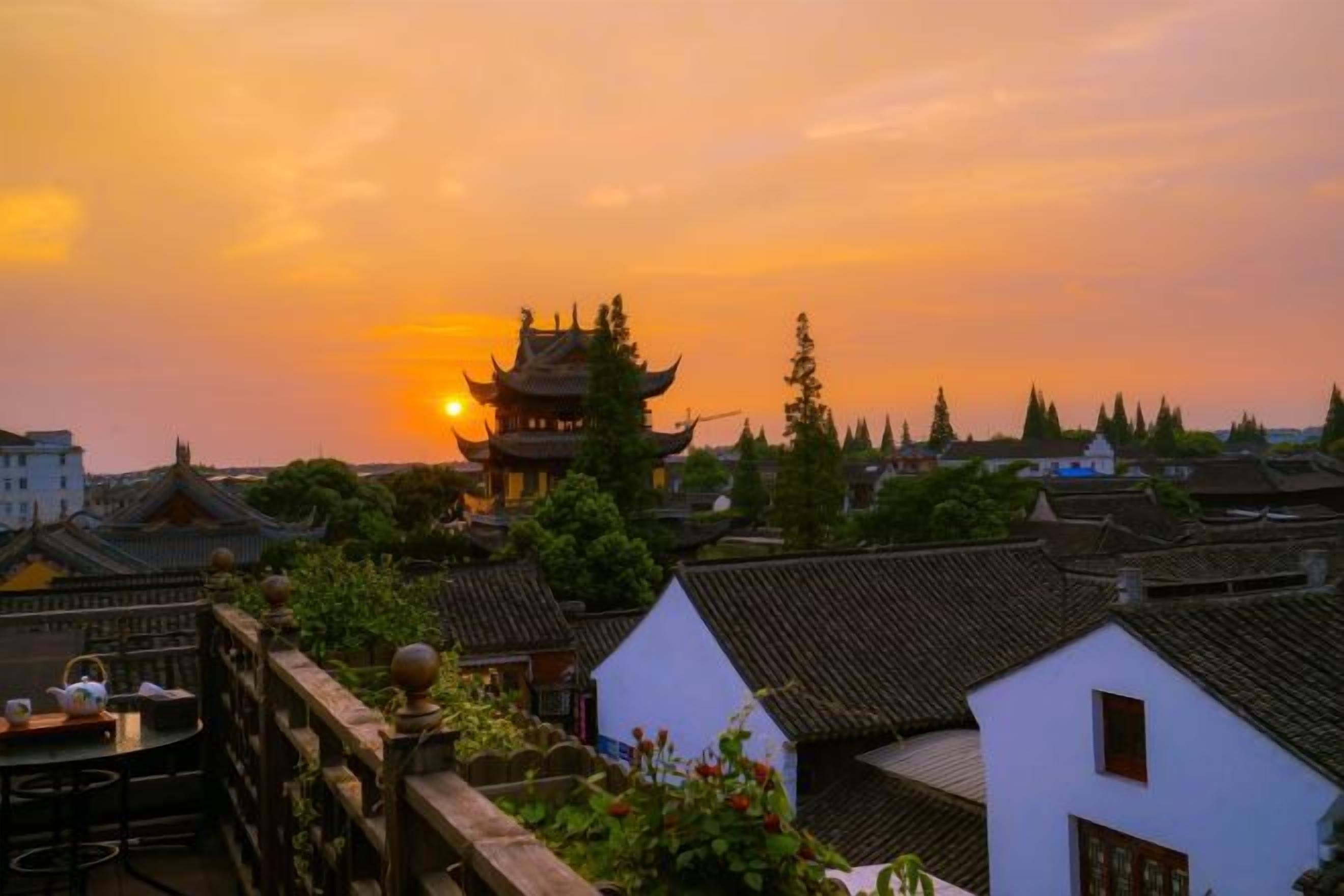 A traditional building with a pagoda-style roof, surrounded by residential houses with similar architecture.