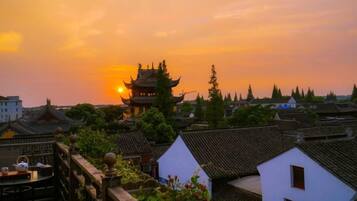 A traditional building with a pagoda-style roof, surrounded by residential houses with similar architecture.