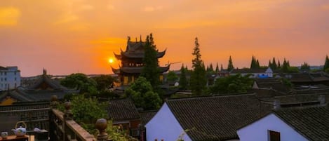 A traditional building with a pagoda-style roof, surrounded by residential houses with similar architecture.
