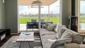 A modern living room with a sofa, a coffee table, and a fireplace. - 5 Star Holiday Home in Lottorp (Löttorp)