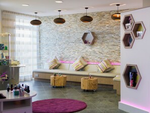 A modern interior with a stone wall, a sofa with striped cushions, wooden side tables, and pendant lighting. - Una Argentum 63 Carbis Bay (Carbis Bay, near St Ives)