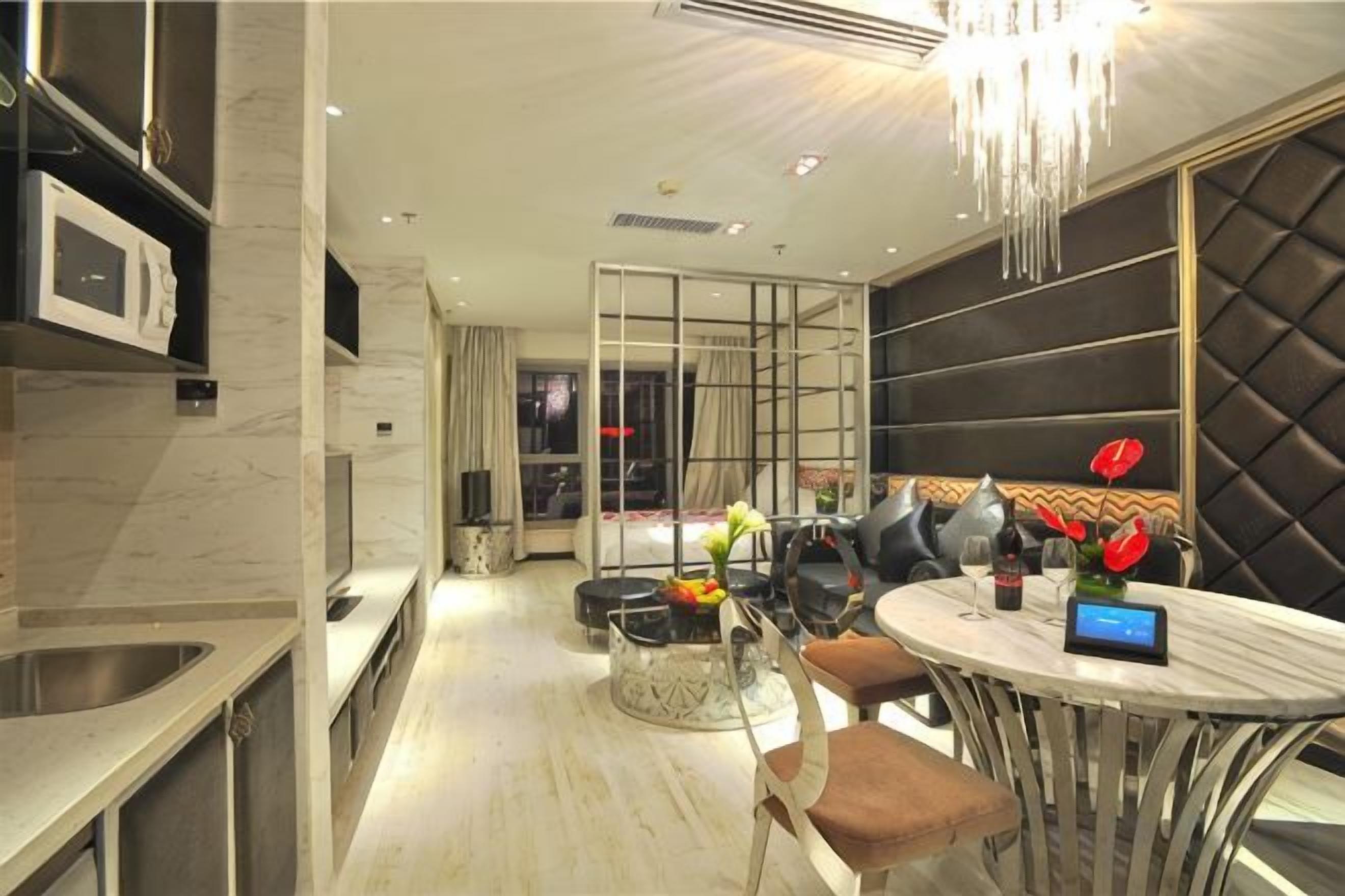 A modern kitchen with a built-in microwave, a dining area with a round table and chairs, and a seating area with a cushioned bench.