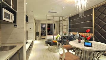 A modern kitchen with a built-in microwave, a dining area with a round table and chairs, and a seating area with a cushioned bench.
