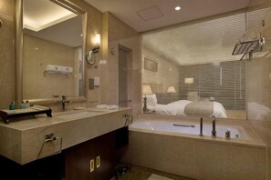 Een moderne badkamer met een grote spiegel, een bad en een wastafelmeubel.
