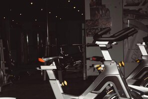Een sportschool met hometrainers en krachtapparaten.