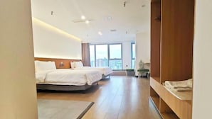 A modern hotel room with two beds, a wooden floor, a large window with a city view, and a wooden wardrobe. - BaiLing Nicesoe Hotel (Guiyang Spray Pool Zilinan) (Guiyang)