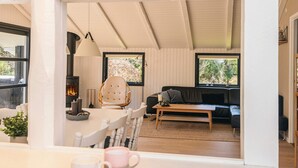 Ein gemütliches Wohnzimmer mit Kamin, einer Essecke mit Tisch und Stühlen sowie einem Sofa.