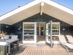 A covered outdoor area with a wooden deck, a grill, and lounge chairs. - 6 Person Holiday Home in Norre Nebel (Norre Nebel)