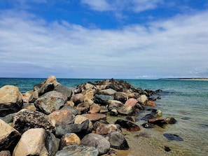 A rocky shoreline with clear water and a distant landmass. - 5 Star Holiday Home in Liseleje (Liseleje)