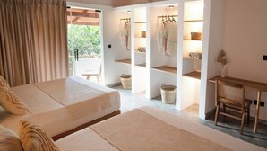 Un dormitorio con una cama grande, un escritorio de madera y estantes con toallas y cestas.