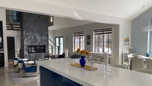 Una cocina moderna con una isla grande, electrodomésticos integrados y un comedor con vistas al exterior.