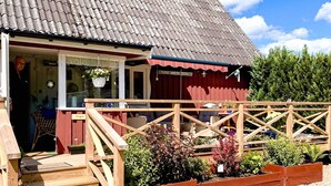 A wooden house with a red exterior and a tiled roof. - Serene Lakehouse With Rowing Boat (Vittsjo)