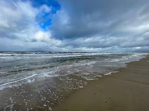 A beach with waves, a cloudy sky, and a clear horizon. - 6 Person Holiday Home in Pandrup (Pandrup)