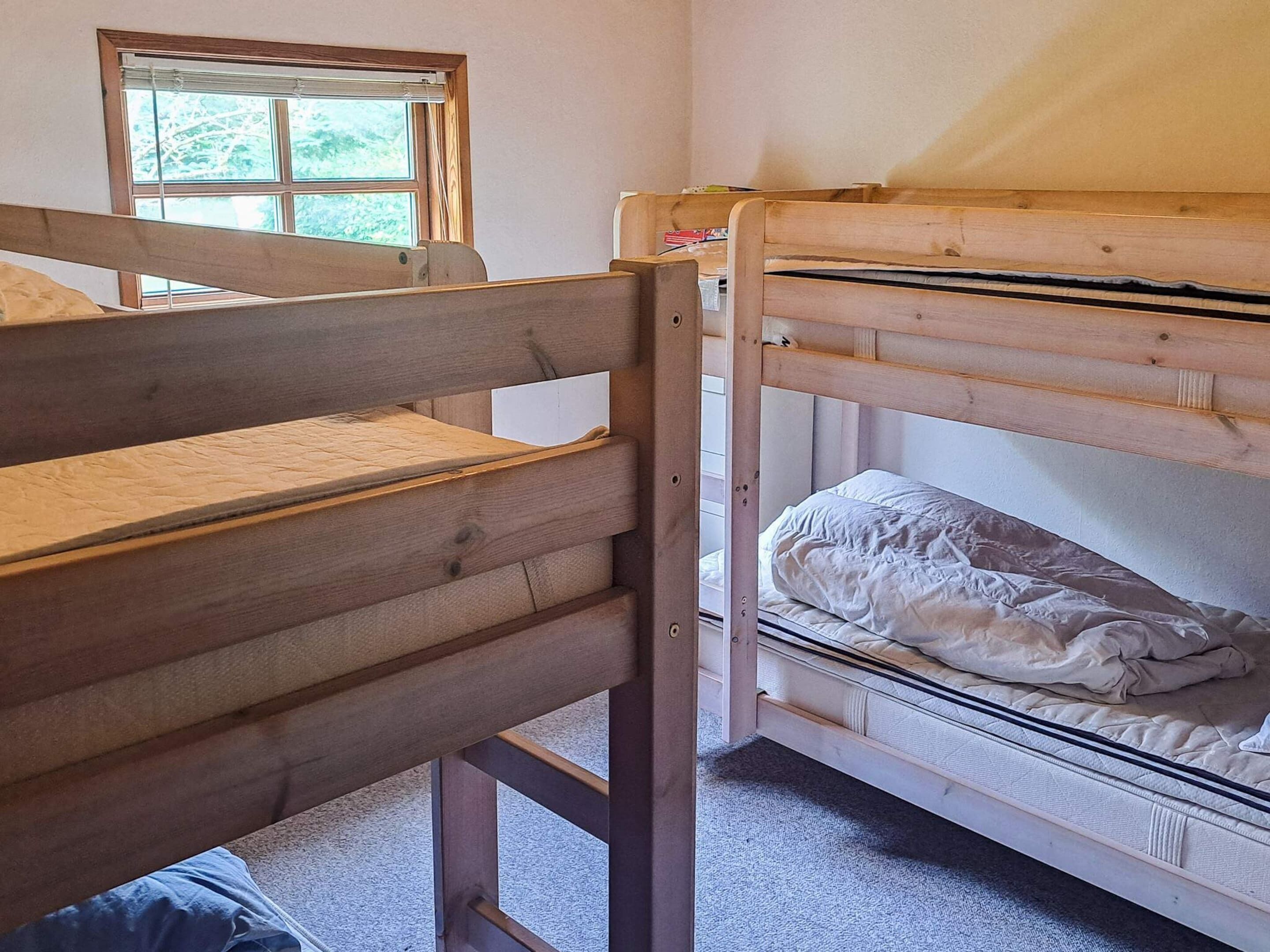 Kerrossängyllä varustettu huone, jossa on ikkuna ja ovi.