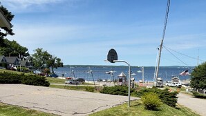 A coastal park with a playground, a basketball hoop, and a view of the sea.