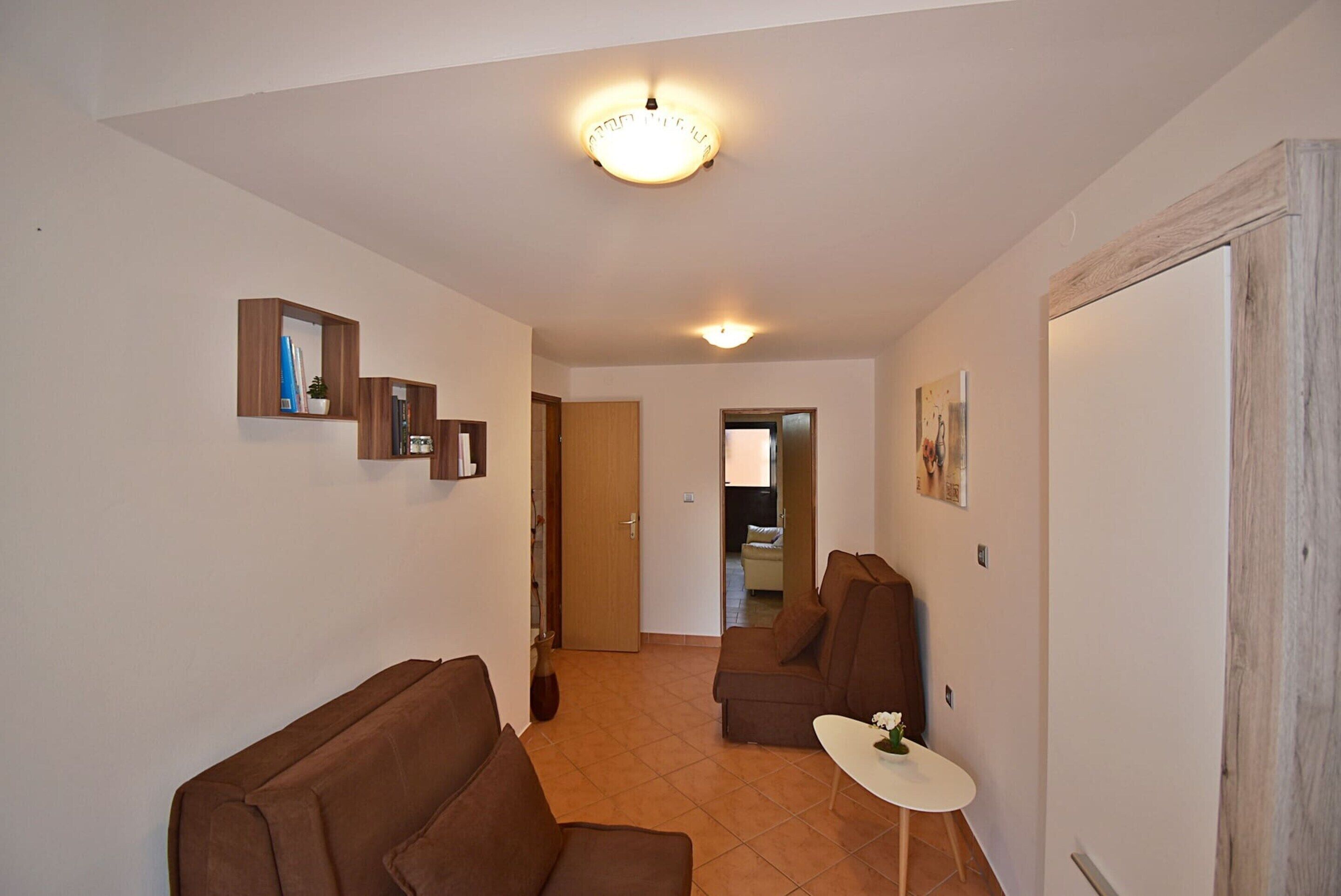 A living room with a sofa, a small table, and a door leading to another room.