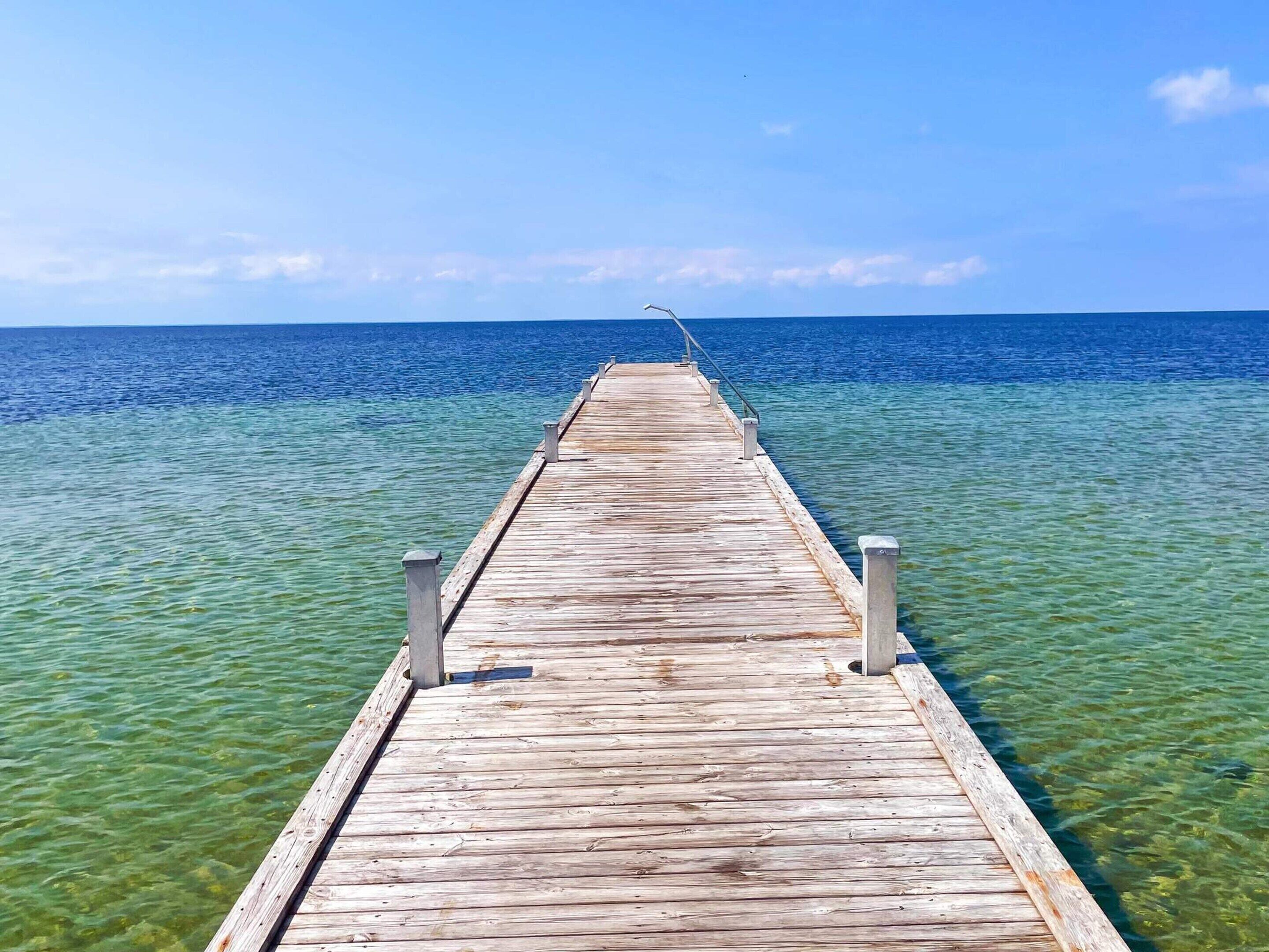 Un muelle de madera que se adentra en aguas azules y cristalinas.