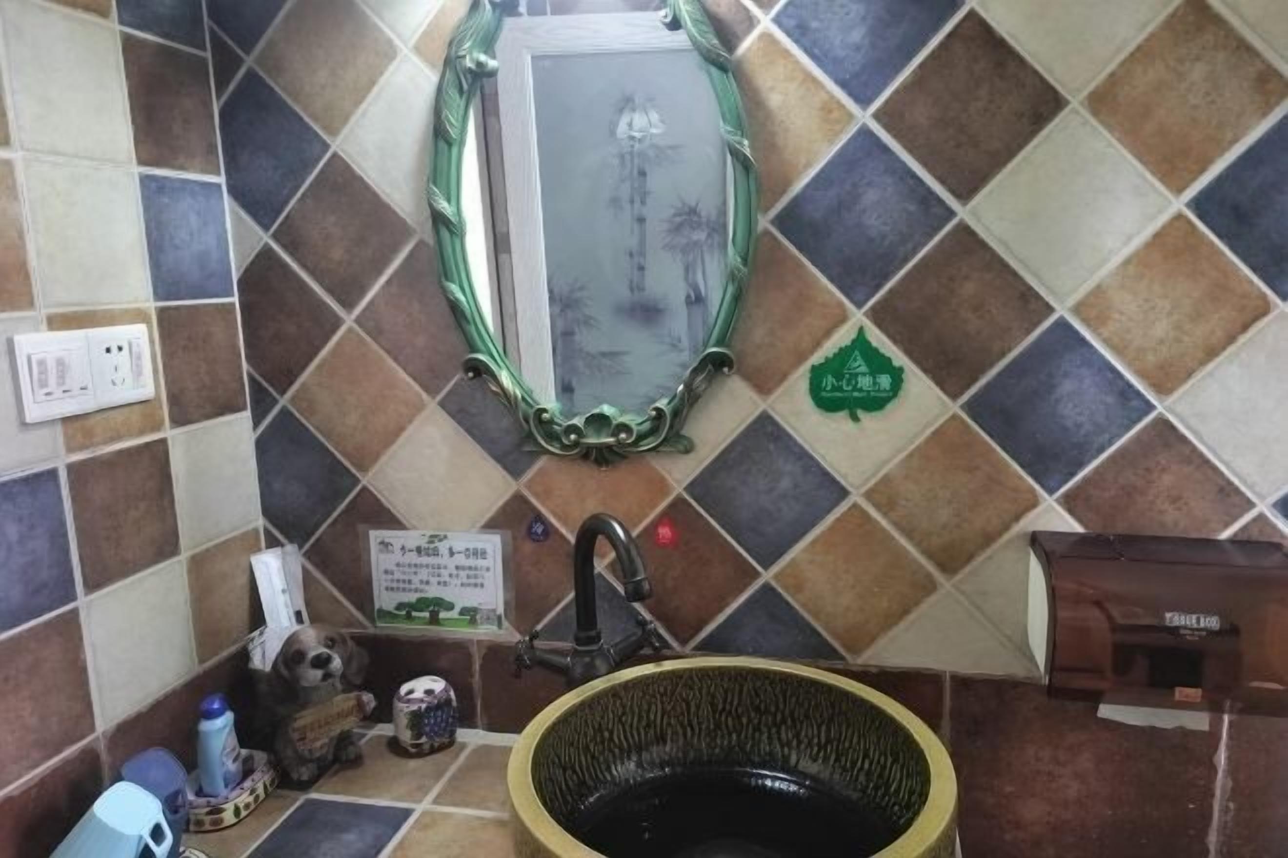 A bathroom with a sink, mirror, and decorative tiles.