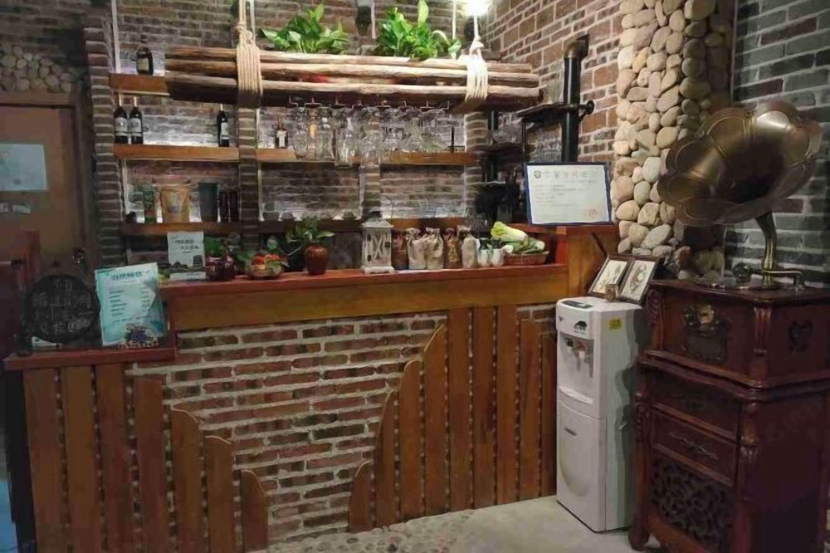 A bar area with wooden shelves, a refrigerator, and a vintage radio.