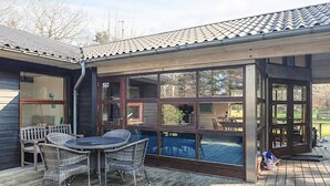 A covered outdoor patio with wicker furniture, a pool, and a view of the surrounding landscape. - 6 Person Holiday Home in Spottrup (Spøttrup)