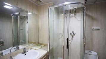 A bathroom with a glass-enclosed shower, a sink, and a toilet.