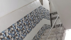 Una escalera con baldosas de diseño geométrico y barandillas de metal.